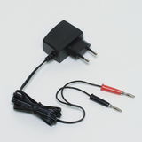 The picture shows a power supply with two cables ending in a plug. The cables are red and black and are typically intended for electrical connections or experiments in educational settings.