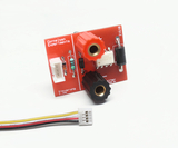 The image shows a red electronic board with various components, including connectors and resistors, that can be used for educational experiments. A connected cable connection is in the foreground, which could be used for control.