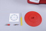 The picture shows experimental materials for physics lessons, consisting of a red spinning top, a compass, a magnet and a yellow pipette. These materials are used to illustrate physical concepts such as magnetism and rotation.