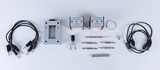 The picture shows a selection of experimental accessories, including wires, two transformers, a universal support and various metal parts. These components are designed for educational experiments in the field of physics or electrical engineering.