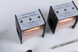 The picture shows two electrical coils with different windings and technical information on the top. The coils are designed for experimental purposes in the educational sector and are not suitable for mains voltage.