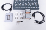 The picture shows a collection of experimental components, including a breadboard, two transformers and several connecting cables. These materials are often used in educational settings to conduct electrical engineering experiments.