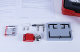 The image shows various components for an educational experiment, including batteries, contacts, a switch and a bell that can be used together. In the background are instructions that provide explanations of the electrical circuits.