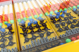 The picture shows a collection of colorful experimental materials, including various colored balls and connecting elements, presumably used to represent molecules or chemical structures. The pieces are neatly arranged in transparent containers lying on a yellow table.