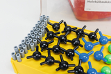 The image shows a molecule construction kit with different sizes and color variations of plastic atom representations in black, blue and green arranged on a yellow base. These models are used to illustrate chemical structures and molecular orientations in educational settings.