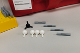 The picture shows a molecular construction kit consisting of colorful plastic pieces, including black and white balls and gray connectors. Next to it is a yellow holder for the pieces, and in the background is a red box with the label &quot;Molecular Construction Kits 1.&quot;