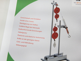 The picture shows a physics experimental device with several pulleys, a hook and a spring balance, which is used to illustrate basic mechanical principles. Next to the device, various topics such as Hooke&#39;s law and the law of the lever are listed.