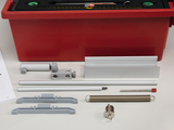 The image shows a collection of experimental materials organized in a red storage case. Among them are various plastic and metal components presumably used for educational physics experiments.