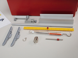 The picture shows a collection of experimental accessories, including brackets, a measuring cylinder, a spring balance and various rods and clips. These components are intended for use in school experiments and scientific investigations.