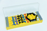The picture shows a colorful experiment kit with various colorful parts that probably represent molecules or atoms. The components are arranged in a yellow container and are intended for use in educational settings.