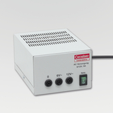 The picture shows a white power supply unit with a ventilation grille and three connections for voltages of 0, 6V and 12V. It is a product of the Cornelsen brand, which is designed for experimental use in education.