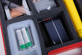 The picture shows an experiment kit that contains various components including a solar cell, batteries, a glass tube and other materials arranged in a foam-padded container. This equipment is suitable for educational purposes in the field of science.