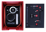 The picture shows an experiment kit packed in a red box. The contents include various glassware, a scale and tubing that can be used for educational chemistry experiments.