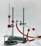 The picture shows a chemical apparatus used to conduct experiments in education. It consists of several pieces of glassware, a tripod and connectors for tubing used in chemical research and teaching.