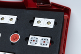 The image shows a sturdy, red storage box filled with foam and containing various experimental building blocks. The building blocks are designed in various shapes and colors, presumably for educational use.