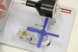 The picture shows an experimental device consisting of various components such as a motor, a switch and a label for the power supply. The labels provide important technical information about the voltage and power of the device.