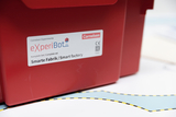The picture shows a red box with the label &quot;eXperiBot&quot; and the addition &quot;Complete Set/Smart Factory&quot;. It is on a background with a blue area and a dashed line, which is probably part of an experiment or learning set.