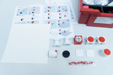 The picture shows components and instructions for an experimental kit that is used to construct a robot. Various modules, a base plate suitable for assembly and assembly materials in a storage box can be seen.