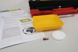 The picture shows a yellow plastic bowl, a magnet with red and silver parts and a white Styrofoam base. In the background you can see several pages of instructions dealing with magnetic experiments.