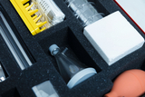 The kit contains various laboratory materials, including an Erlenmeyer flask, beakers, cotton swabs, and a foam insert. This equipment is typical for science experiments in schools.