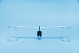 Two transparent cups are placed on a blue surface, holding a straight transparent tube from which a black weight hangs. This arrangement could be used for experiments measuring forces or demonstrating balance.