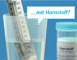The image shows a transparent container containing water and a thermometer immersed in the water. Next to the container is a container labeled &quot;Urea,&quot; indicating possible chemical experiments.