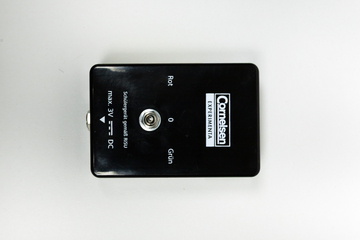 A black experiment device features a connector socket and colored labels in red and green. It is designed for use in schools and supports a maximum voltage of 3 volts DC.