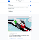 Ein Roboterfahrzeug namens "The Blue Collector" ist auf einem Spielmatten-Layout abgebildet und fährt über einen blauen Abschnitt. Es dient dazu, Rohmaterialien zu sammeln und zum sogenannten "Gripper" zu bringen, um den Recyclingprozess zu unterstützen.