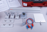 Ein Physik-Experimentierset mit Lineal, Halterungen, Kabeln und einer Metallplatte ist auf einer grauen Fläche ausgebreitet. Im Hintergrund liegen eine Bedienungsanleitung sowie ein roter Transportkoffer der Marke Cornelsen.